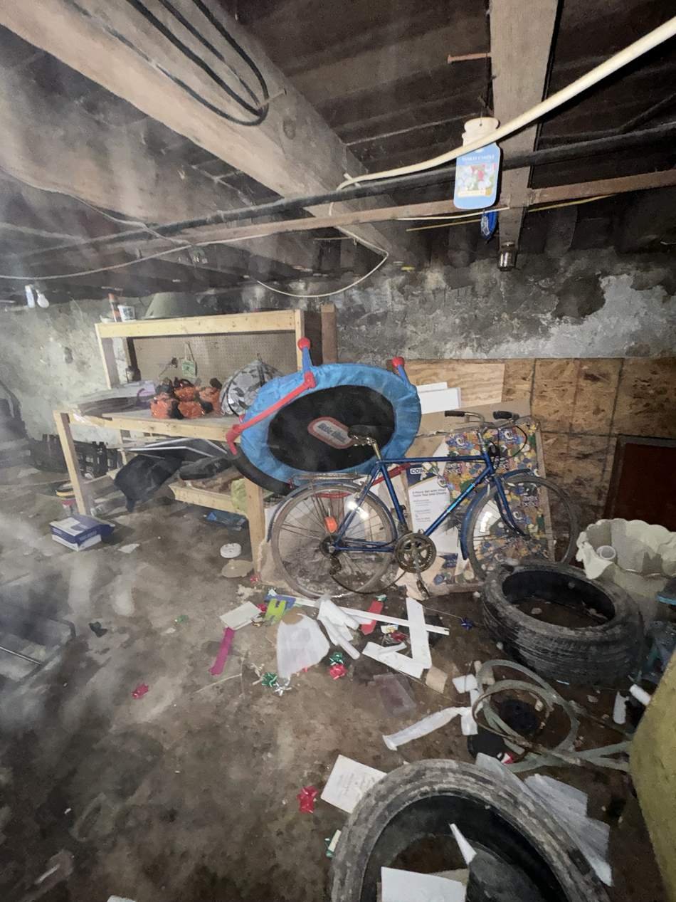 Basement packed with old furniture and clutter before cleanout