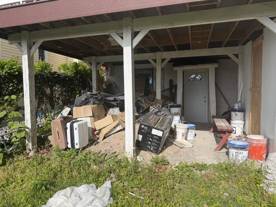 Porch piled high with debris and discarded household items